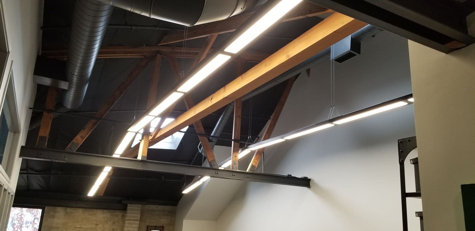 Open ceiling with exposed trusses and linear lighting