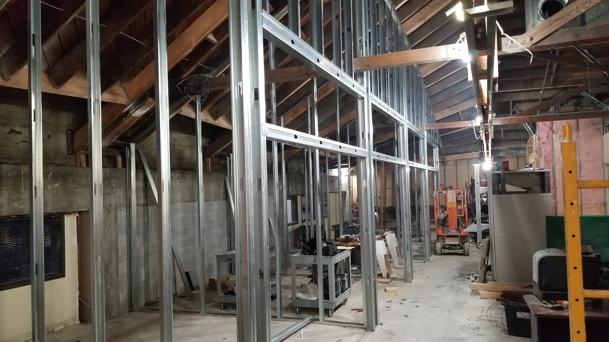 Metal-stud framing for the private offices under the existing wood-truss roof