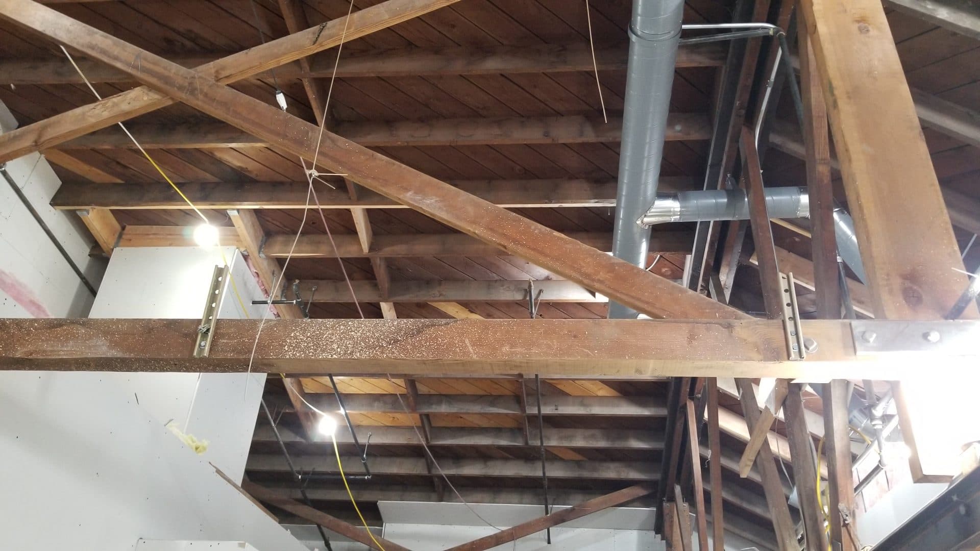 Original heavy-timber trusses with steel connections and new HVAC duct run