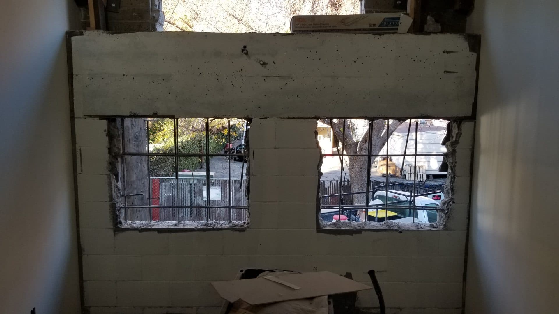 Concrete block exterior wall saw-cut for new window openings, rebar exposed