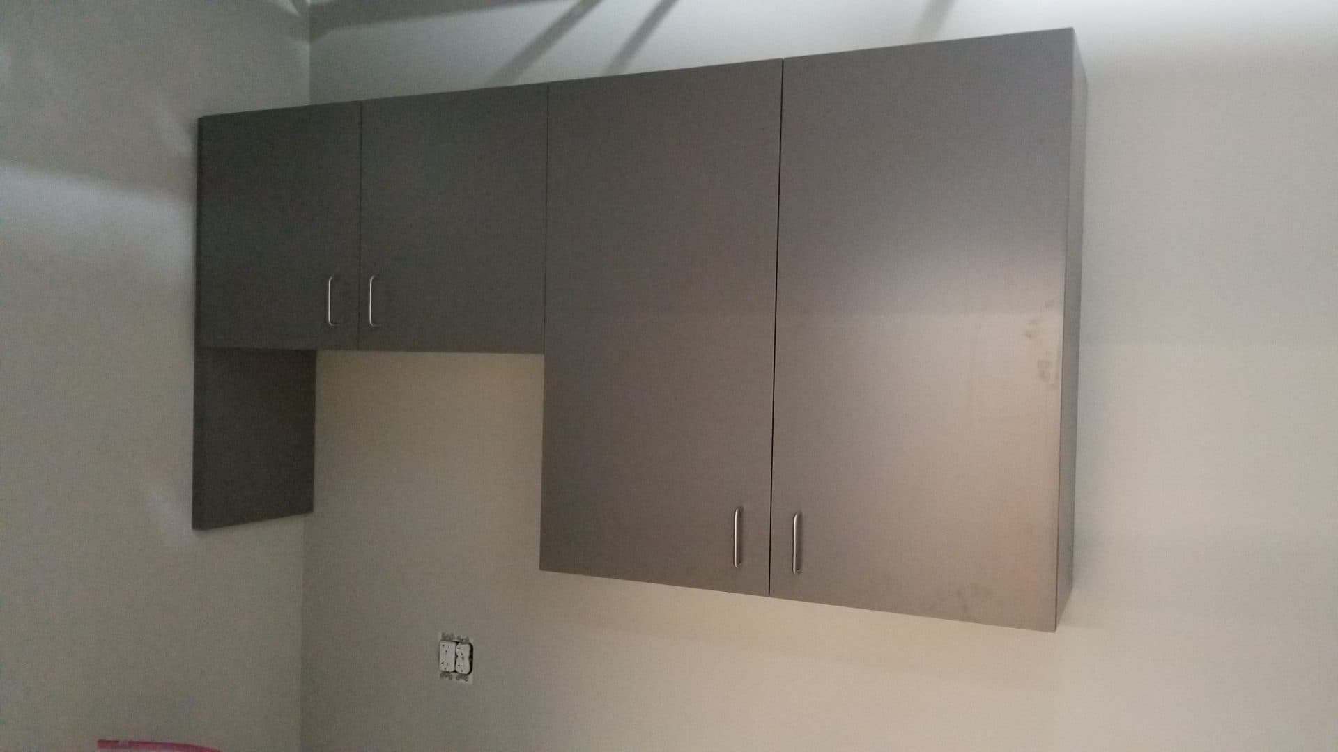 Gray laminate upper and lower cabinets installed in the break room