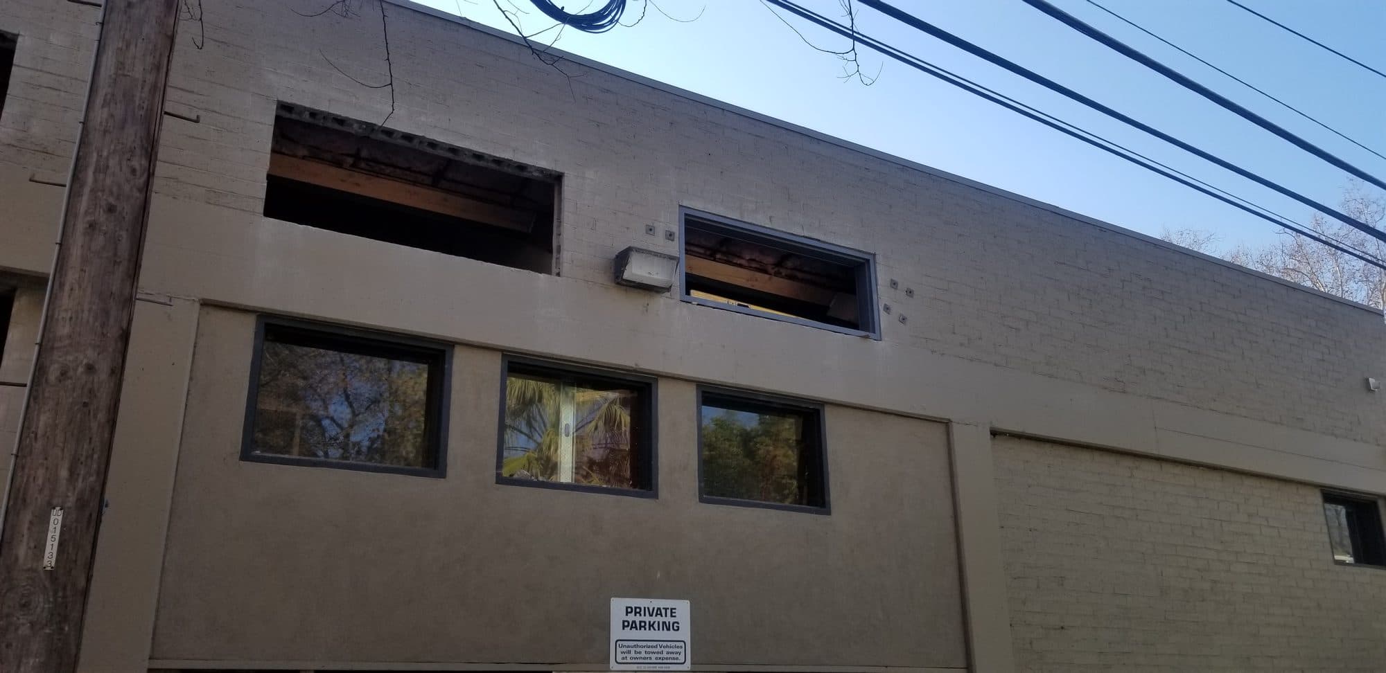 New second-floor window openings cut into the masonry exterior