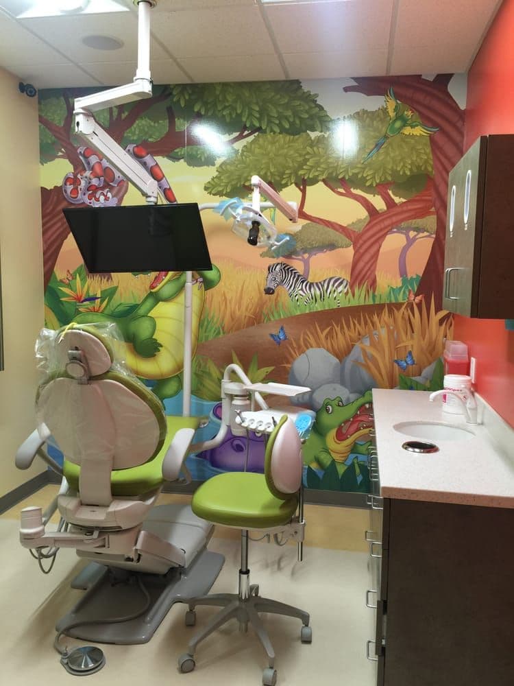 Pediatric treatment room with jungle mural and empty dental chair
